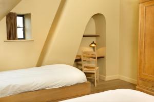 a room with a bed and a desk with a ladder at De Grote Wateringe in Damme