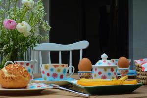 una mesa con huevos, platos y tazas. en Beeltjens B&B: Wolf&Belle, en Westerlo