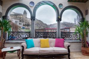 a couch with colorful pillows on a balcony with a view at Grand Elite Cave Suites in Goreme