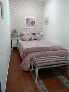 a bedroom with a bed with a bench next to it at Apartamento Sado II in Setúbal