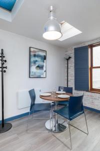 une salle à manger avec une table et des chaises bleues dans l'établissement The Loft Brighton, à Brighton et Hove 9 autres photos