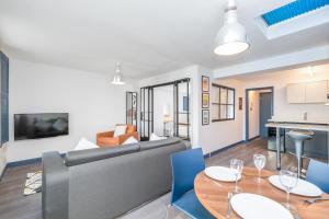 un salon avec un canapé, une table et des chaises dans l'établissement The Loft Brighton, à Brighton et Hove