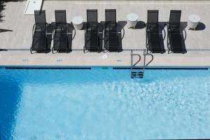 a swimming pool with chairs and a swimming pool at Nura Santa Ponsa & Spa in Santa Ponsa