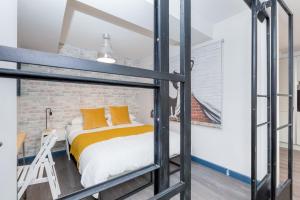 une chambre en mezzanine avec un lit et un mur de briques dans l'établissement The Loft Brighton, à Brighton et Hove