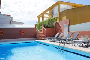 a swimming pool with chairs next to a house at Nura Santa Ponsa & Spa in Santa Ponsa