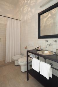 a bathroom with a sink and a toilet and a mirror at Masseria Montelauro in Otranto