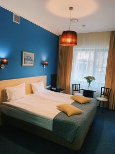 a bedroom with a large bed with a blue wall at Antic in Moscow