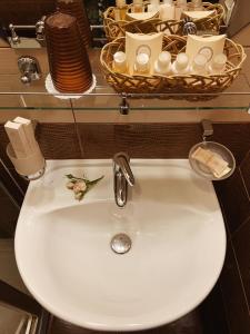 a bathroom sink with a mirror, soap dispenser, and other items at Antic in Moscow