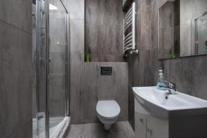 a bathroom with a toilet and a sink and a shower at Apartamenty Sea Side Apartinfo in Jastrzębia Góra