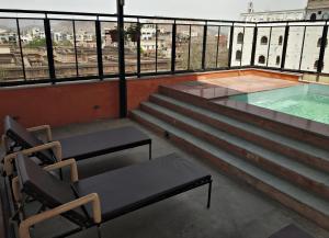 a balcony with stairs and a swimming pool on a building at Gypsy Monkey in Jaipur