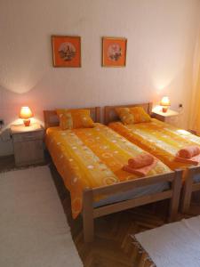 2 camas en una habitación con 2 lámparas en la pared en Sobe Dijana, en Subotica