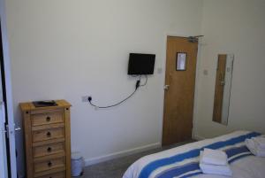 a bedroom with a bed and a television on the wall at The Sandhill in Sandown