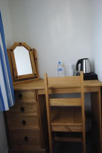 a wooden desk with a mirror and a chair at The Sandhill in Sandown