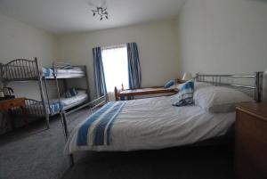 a bedroom with a bed and bunk beds and a window at The Sandhill in Sandown