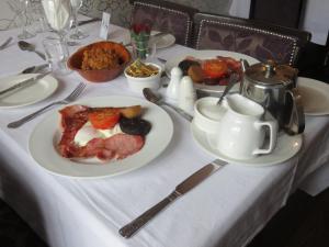 uma mesa com pratos de comida numa toalha de mesa branca em Riverside Guesthouse em Charlestown