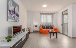a living room with an orange couch and a tv at Apartments Kimi in Rovinj