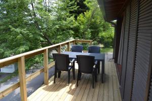 een veranda met een tafel en stoelen op een terras bij Sunclass Tignale bungalow S37 in Tignale