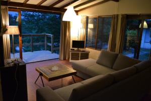 een woonkamer met een bank, een tafel en een televisie bij Sunclass Tignale bungalow S37 in Tignale