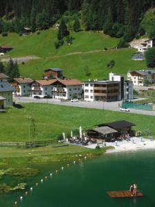 a large body of water with buildings and a resort at Haus Tyrol in See