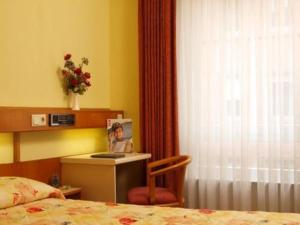 a bedroom with a bed and a chair and a desk at Hotel Zurich in Luxembourg