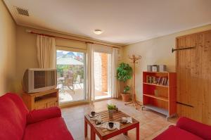 a living room with a red couch and a tv at Villas Guzman - Bernia in Calpe