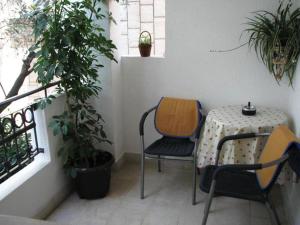 un tavolo e sedie su un balcone con piante di Oaza Guest House a Sveti Stefan Altre 37 foto