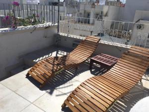 2 Holzstühle und ein Tisch auf dem Balkon in der Unterkunft Romi' in Polignano a Mare