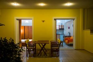 a dining room with a table and chairs and a bedroom at Vakis apartments in Zacharo