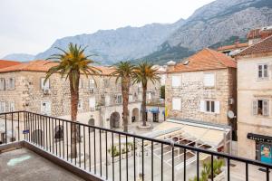 Blick auf eine Stadt mit Palmen und Bergen in der Unterkunft RUŽA in Makarska