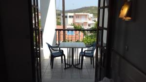 a table and chairs on a balcony with a view at Amaliahotel in Apolakkiá