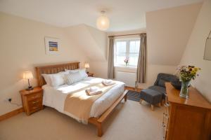 a bedroom with a large bed and a chair at Feochan Bheag in Oban