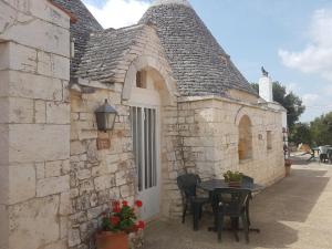 a small stone building with a table and chairs at Masseria Gianca in Cisternino +74 photos