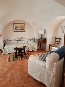 a living room with a couch and a bed at Masseria Gianca in Cisternino