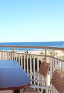 a blue table and chairs on a balcony with the beach at Apartamento Sirenas, frente al mar in Gandía