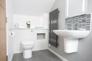 y baño con aseo blanco y lavamanos. en Dunmurray Lodge Guesthouse and Loft Apartment, en Pitlochry
