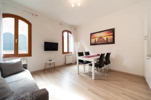 sala de estar con mesa, sillas y sofá en Serenissima Apartments, en Venecia