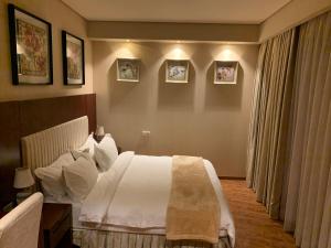 a hotel room with a bed and pictures on the wall at 2 bedroom Apartment in Oasis in Chakvi +45 photos