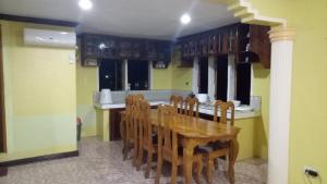 a kitchen with a wooden table and chairs at Xylla Guesthouse in Ytaya