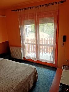 a bedroom with a bed and a window with a balcony at Attila Hotel Budapest in Budapest +43 photos