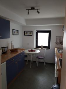 een keuken met een tafel en een tafel en een raam bij Haus Ella in Homburg