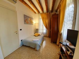 a bedroom with a bed and a flat screen tv at Alloggi Alla Rivetta in Venice