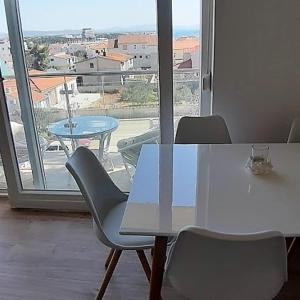 a table and chairs with a view of a balcony at Apartments Nika's View in Vodice