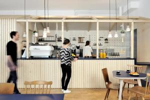 a woman standing at a counter in a kitchen at SLO Hostel Lyon les Pentes in Lyon