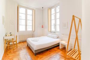 a white bedroom with a bed and a desk at SLO Hostel Lyon les Pentes in Lyon