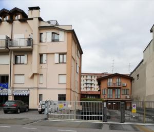 a building with cars parked in a parking lot at Rovelli Room in Bergamo