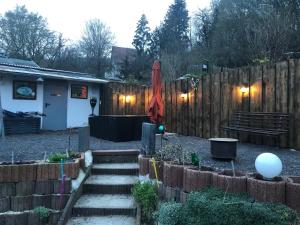 einen Garten mit Treppen, einem Zaun und einem Regenschirm in der Unterkunft Schöne Ferienwohnung in Eisenach