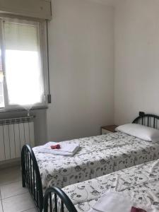 een slaapkamer met twee bedden en een raam bij Residence Mariele in Tavazzano