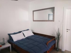 a blue bed in a room with a mirror at Super Nuova - Private Parking in Thessaloniki