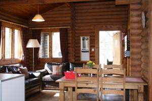 a living room with a couch and a table and chairs at Highgarry Lodges in Invergarry