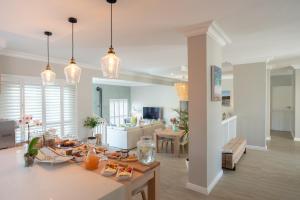 una cucina e un soggiorno con luci a pendolo di Bentley's Guesthouse a Bloubergstrand